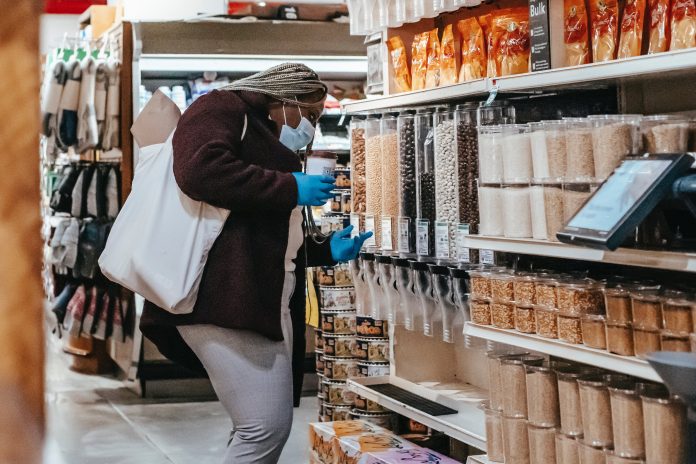 A woman shopping at a refill section in a local supermarket