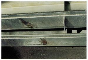 Description: Staining and coating defects around vent holes.Cause: Pre-treatment liquors penetrating sealed overlap areas and boiling-out during immersion in the molten zinc, causing localised surface contamination. Remedy: Seal vent holes with temporary plugs (silicone) prior to pre-treatment. Pre-heat item prior to immersion in zinc bath to dry out overlap area as much as possible.