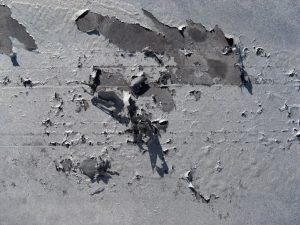 Peeling between ETA and Zeta layers caused by abrasive blasting, where the substrate has been affected by the Kirkendall Effect (voids). This in turn contaminates the painting facility, where flaking material contains 1.5% lead.